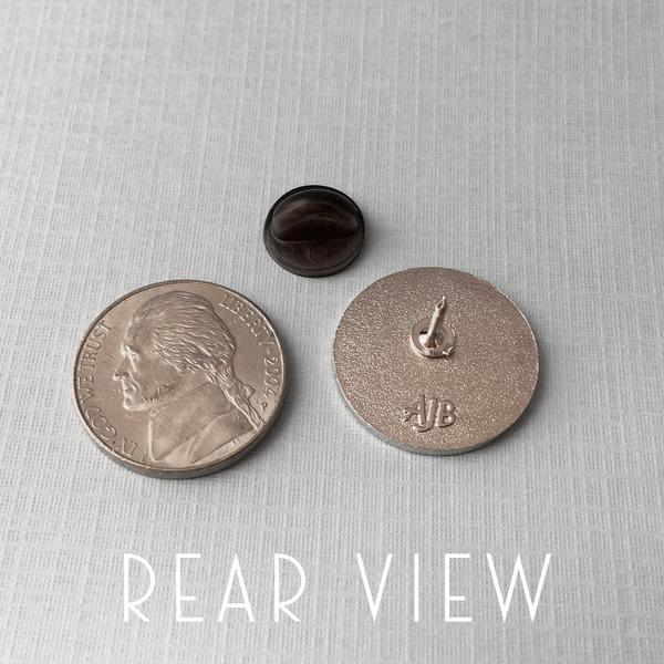 By Rather Keen. It's a Trap - Admiral Ackbar Quote Pin: "It's a trap!" —Admiral Ackbar, Return of the Jedi. White enamel and silver tone metal pin. Black rubber clasp. Measures 3/4 x 3/4 inch (2 cm). Also available in store at FOLD Gallery DTLA.