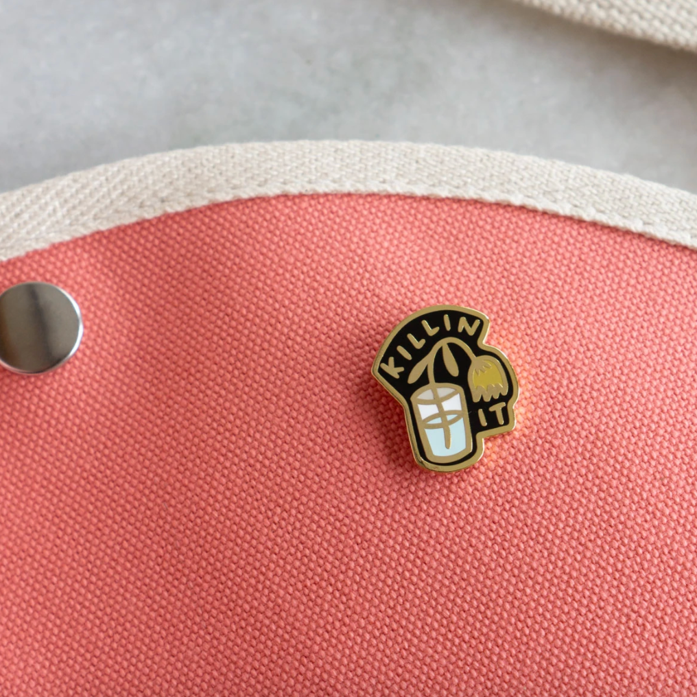 By Stay Home Club. Killin' It Pin details: Gold metal and hard enamel. Comes with a metal locking pinback so it'll stay on your stuff real good! Measures 1"x.75". Please note that due to everyone’s monitor displaying differently, the colors you see may vary.