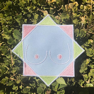 By Adele by Adele Jackson. Iron on backing machine embroidered Boob Patch. Measures 4 inches. At FOLD Gallery.