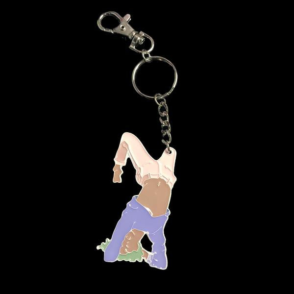 By Adele by Adele Jackson. Out of the Box Girl Keychain. Soft enamel white painted metal keychain with silver chain and closure. Measures 2 1/2 inches. Also available in store at FOLD Gallery DTLA.