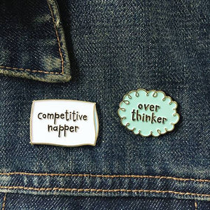 By Carolyn Draws. Enamel Competitive Napper Pin with gold colored plating and a gold butterfly clasp on the back. Please note that due to everyone’s monitor displaying differently, the colors you see may vary. Measures 1.25 inches wide.