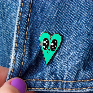 By Chris Uphues. This Minty Heart Pin is made with super shiny black nickel and filled with smooth, high quality, enamel in seafoam and white. Pin comes with a rubber clutch for extra grip and mounted on Chris Uphues packaging. Perfect for gifting! Pin measures 1 inch tall. Also available in store at FOLD Gallery DTLA.