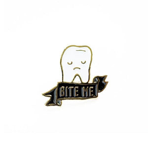 By Ilootpaperie. Soft enamel Bite Me Tooth Pin with gold base. Ships as a single pin on card. Measures 1 inch.
