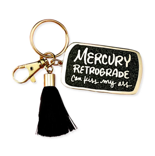 By Little Arrow. Mercury Retrograde Keychain: Cloisonné hard enamel set in 22kt plated gold. Plated gold hardware and adorned with a black silk tassel. Large lobster clasp. Measures 1.25 x 2 inches. Also available in store at FOLD Gallery DTLA.