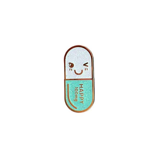 By Little Arrow. Mr. Happy Pill Pin - Iridescent Teal Glitter. Cloisonné hard enamel set in 22kt plated gold. Rubber clasp. Measures 1 x 1.75 inch. Also available in store at FOLD Gallery DTLA.