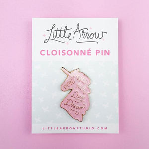 By Little Arrow. Unicorn Daydreams Glitter Pin. Cloisonné hard enamel set in 22kt plated gold. Dual pins with rubber backs. Available in White Iridescent or Pink Iridescent. Measures 1 x 1.75 inches. Also available in store at FOLD Gallery DTLA.