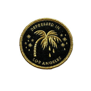 By Little Friends of Printmaking. Embroidered Depressed in Los Angeles Patch. Being bummed out has never been so exciting. Embroidered in metallic gold thread on black felt! Measures 3 x 3 inches.