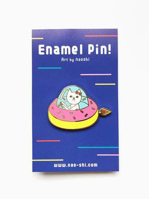By Naoshi. Cat in a Donut Pin features: Hard enamel finish. Shiny gold metal plating. 2 posts and gold pin backs to hold securely in place. Packaged with a backing card in a plastic sleeve. Measures 1 x 1.6 inches. Also available in store at FOLD Gallery in DTLA.