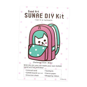 By Naoshi. With this Cat in a Rucksack SUNAE DIY Kit, you can make your own fun and easy SUNAE (Sand Art)! Contents of SUNAE DIY Kit: Colored Sand. SUNAE board (Pre-cut). Instructions. Coarse Paper. Toothpick. Wrapping Ribbon. Kit measures 4 x 6 inches. Also available in store at FOLD Gallery in DTLA.
