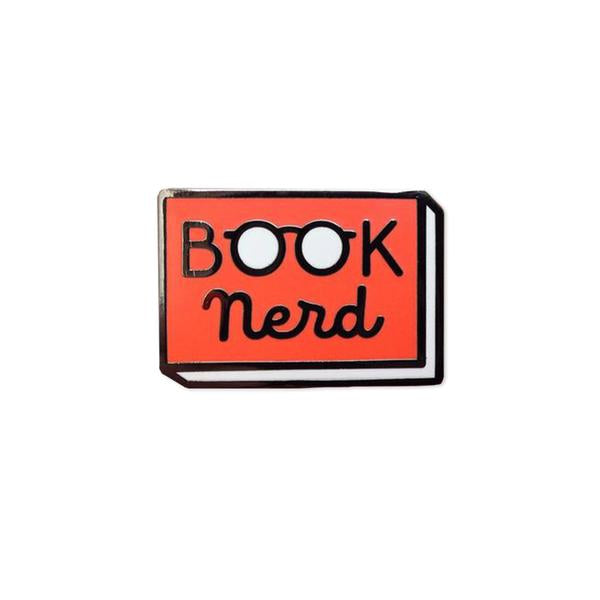 By Rather Keen. Hard enamel Book Nerd Pin. Bright red enamel and black metal with black rubber clasp. “When in doubt, go to the library.” —Hermione Granger. Measures 1 inch wide. Also available in store at FOLD Gallery.
