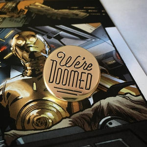 By Rather Keen. We're Doomed Star Wars C-3PO Quote Pin. For when your odds of successfully navigating an asteroid field are approximately 3,720 to 1. This pin features C-3PO's pessimistic dialogue in Star Wars. The reflective gold surface is just like C-3PO's head! Black enamel. Black rubber clasp. 3/4 x 3/4 inches. Also available in store at FOLD Gallery DTLA.