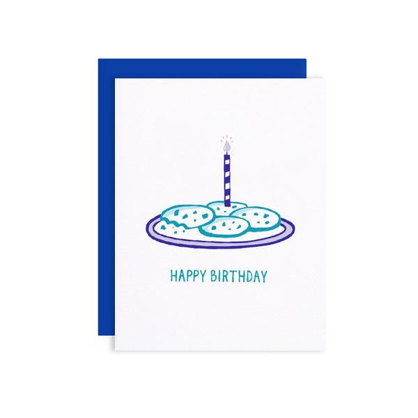 By Loudhouse Creative. The Birthday Cookies Card features: two-color letterpress printing, hand-drawn illustrations, 100% brilliant white cotton paper, blank inside, matching blue envelope and cello sleeve packaging. Hand-printed on an antique letterpress in Los Angeles, California. FOLD Gallery Dtla.