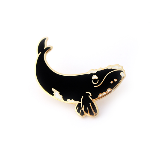 by SHOAL. One hard enamel Right Whale Pin. Shiny gold metal, glitter details. Two rubber pin backs. "OH PLESIOSAUR" and "Natelle Draws Stuff" stamped on reverse. Measures 1.5-inch (38mm). Also available in store at FOLD Gallery DTLA.