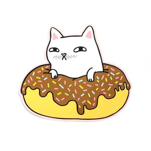 By Shoal. White Cat Donut Sticker. Made of durable vinyl with a protective coating. Withstands UV and is waterproof. Measures 4 inches on its longest side. FOLD Gallery Dtla.