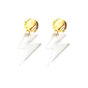 By Sleepy Mountain. Lightning Bolt Dangle Earrings: Gold studs with clear acrylic lightning bolt dangles. Light weight and comfortable. Mirror gold acrylic circle. Titanium stud attached to the back (Nickel-free, safe for sensitive ears). Clear acrylic. Measures overall size 2 inches. Bolt size 1.4 inches. Also available in store at FOLD Gallery DTLA.