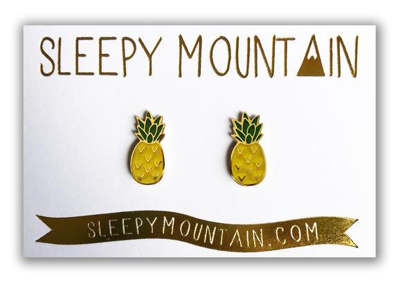 By Sleepy Mountain. Pineapple Earrings: Enamel color earrings are 22k gold plated stainless steel Includes butterfly backings as well as nylon stops. For long lasting earrings, keep them dry, do not wear them in the shower. Measures 0.5 inches. Also available in store at FOLD Gallery DTLA.