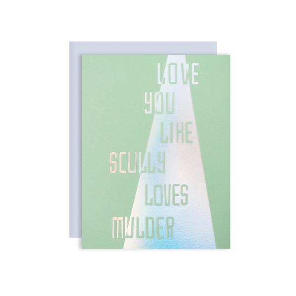 by The Good Twin. Scully and Mulder Card. Holograph foil stamped on green paper. Packed in a cello sleeve with corresponding envelope. Envelope color may vary. Blank inside. Measures 4.25 x 5.5 inches folded. Also available in store at FOLD Gallery DTLA.