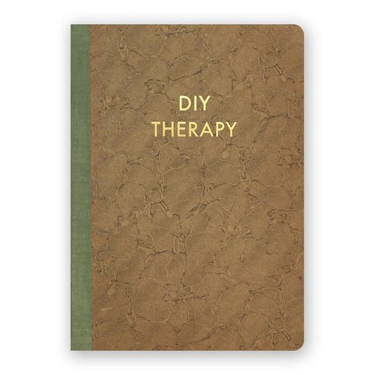 By The Mincing Mockingbird & The Frantic Meerkat. DIY Therapy Journal features 120 ruled pages of 120 gsm creamy off-white paper that takes ink beautifully. Stylish gold foil stamped cover. Binding lies flat when open. Measures 5 x 7 inches — perfect size for a purse or for traveling.