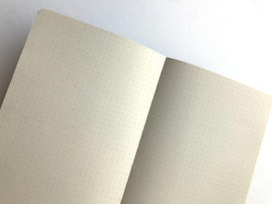 By The Mincing Mockingbird & The Frantic Meerkat. Half-Assed Ideas Journal: 128 dotted grid pages of 120 gsm creamy off-white paper that takes ink beautifully. Binding lies flat when open. Measures 7.75" tall x 9.75" wide.