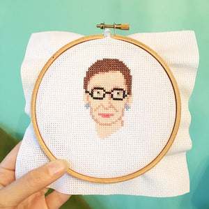 By The Stranded Stitch. You can now cross stitch a portrait of the unstoppable RBG with the Ruth Bader Ginsburg DIY Cross Stitch Kit! Kit Includes: Basic cross stitching instructions. Counted cross stitch pattern. DMC embroidery floss and color chart. 14 count white aida cloth. 5 inch Embroidery hoop. Needle. FOLD Gallery Dtla.
