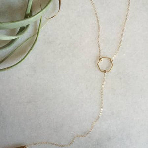 By TUMBLE. Gold Filled Hexagon Lariat Necklace: This is a 16-inch lariat necklace with a 6 inch drop. All together to form a very graphic and minimalist design. Made with gold-filled chain. Also available in store at FOLD Gallery DTLA.