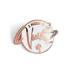 by World Famous Original. White hard enamel I Need a Vacation Pin with rose gold finish and rubber clasp. Measures 1.25 inches. Also available in store at FOLD Gallery DTLA.