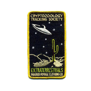 By Maiden Voyage Clothing Co. This Extraterrestrials Patch is reminiscent of the old fashioned National Park patches, but features a cryptid character in their natural habitat! Show your support for the Cyrptozoology Tracking Society! Iron-on (sewing still recommended). Measures 2.5"w x 4.25"h.